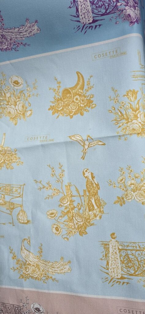 Détail de la toile Cosette Paris : corne d'abondance et motifs dorés sur fond bleu
